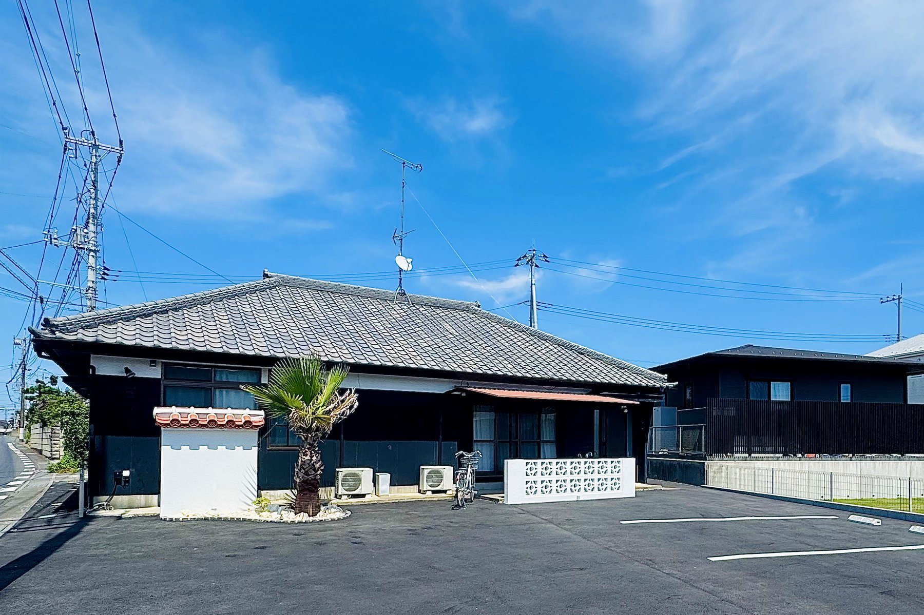 赤瓦の門と花ブロック、ヤシの木が目印の那珂湊教室の外観